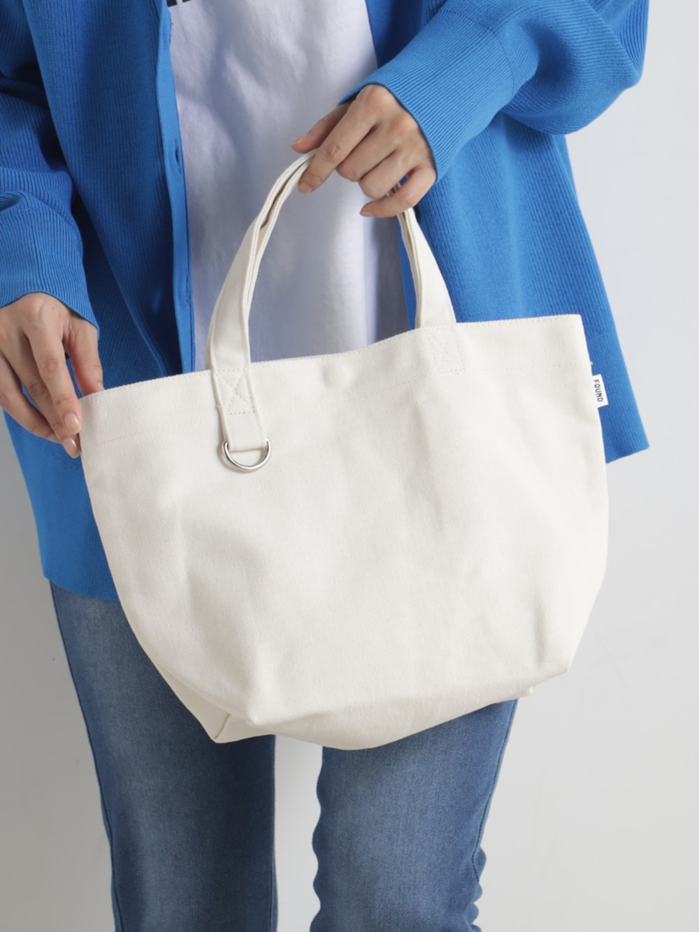 ブルー系のトップス、ベージュ系のトートバッグ、ベージュ系のその他シューズを着用したレディースの冬コーディネートの3枚目の写真