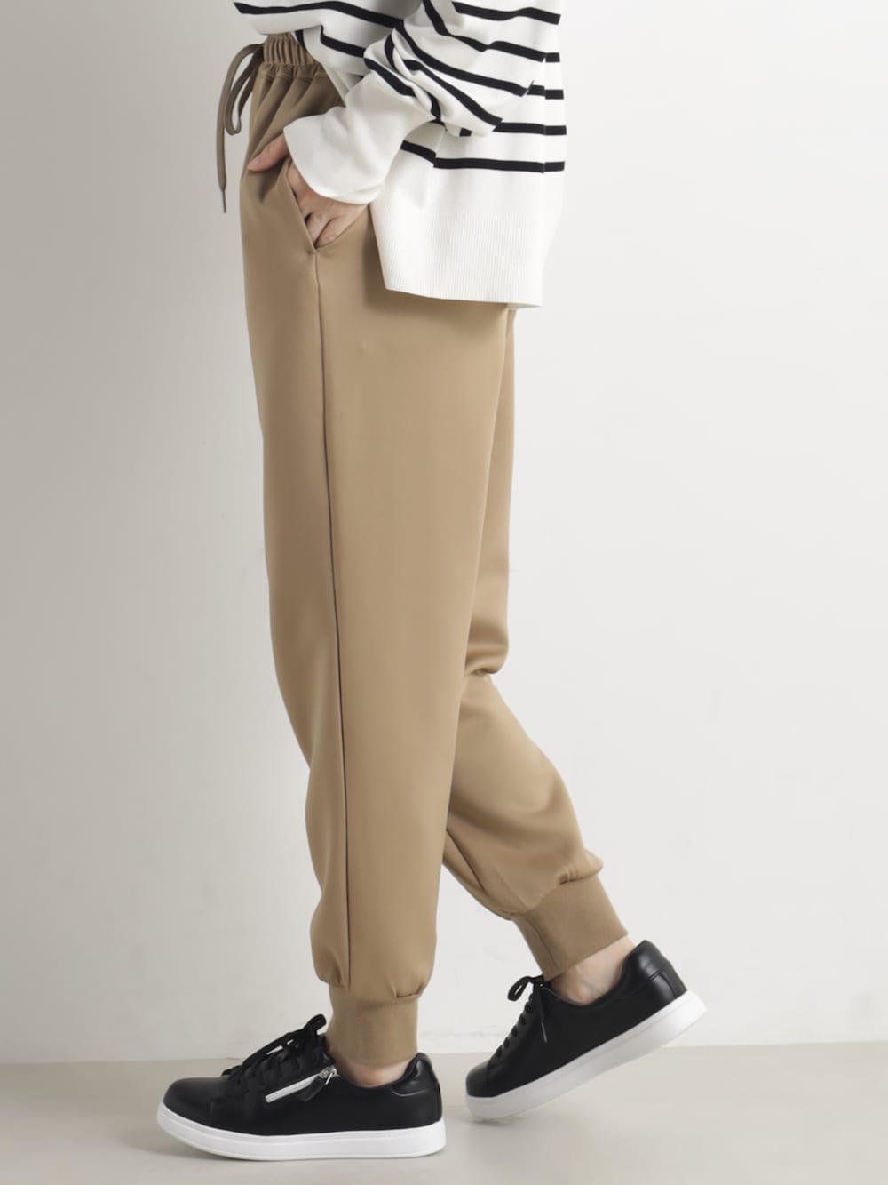 グレー系のニット/セーター、ブラウン系のその他パンツを着用したレディースの春コーディネートの3枚目の写真