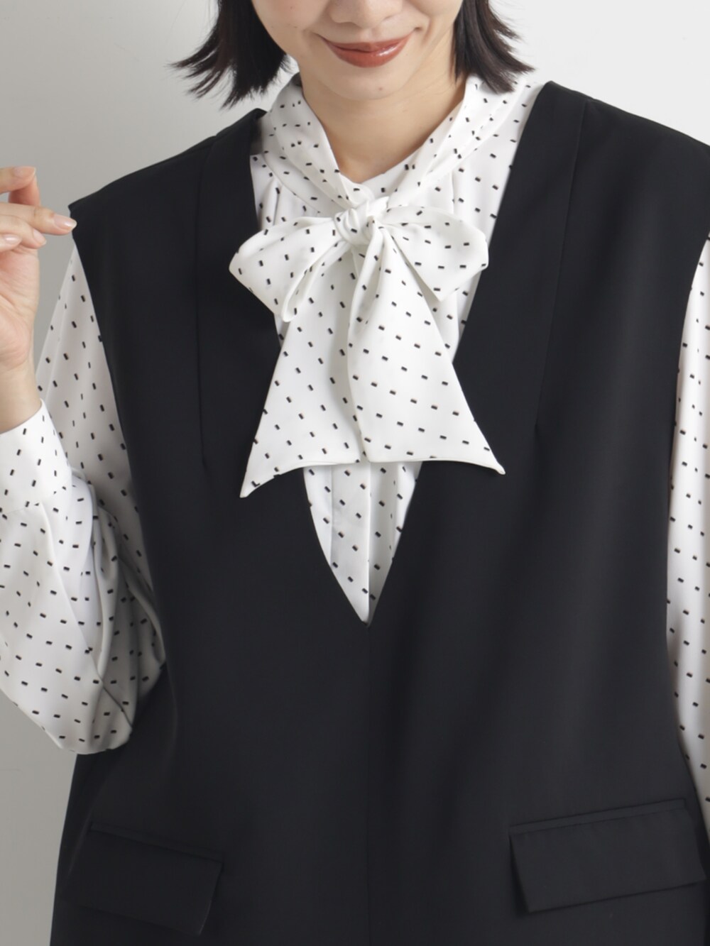 ブラック系のパンプス、グレー系のシャツ/ブラウスを着用したレディースの春コーディネートの2枚目の写真