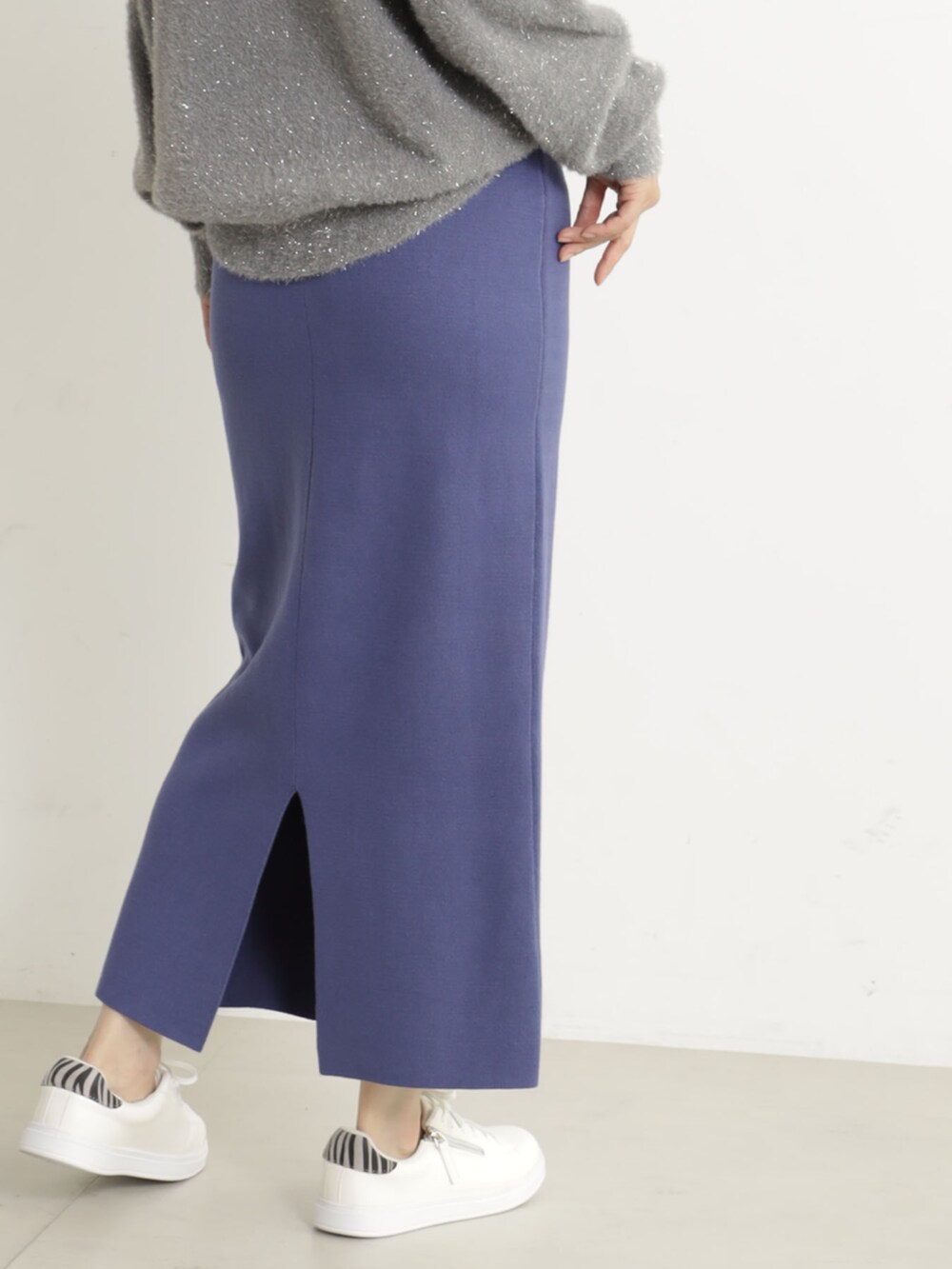 グレー系のニット/セーター、ブルー系のスカートを着用したレディースの冬コーディネートの6枚目の写真