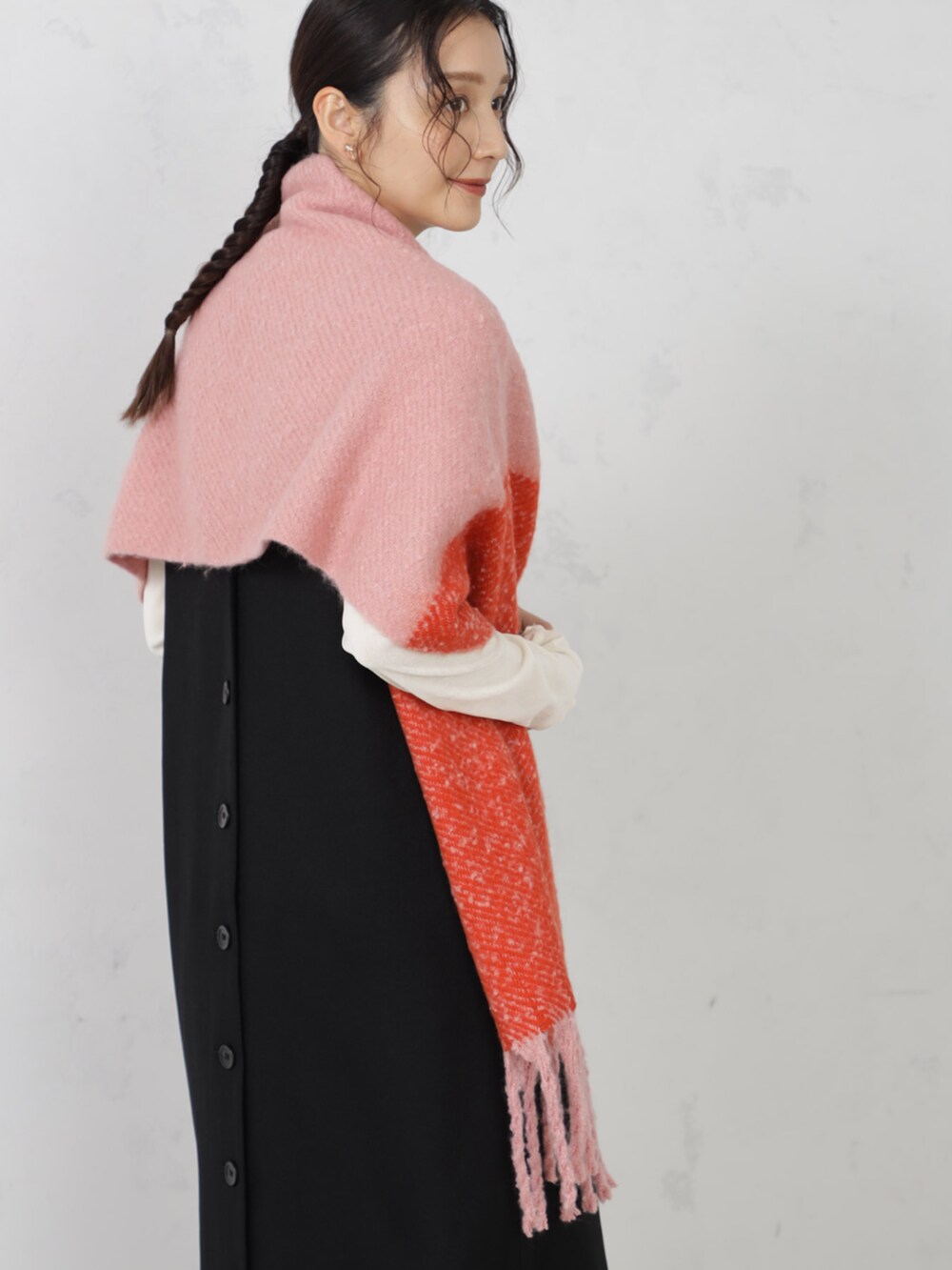 ブラック系のワンピース、ピンク系のマフラーを着用したレディースの秋コーディネートの2枚目の写真