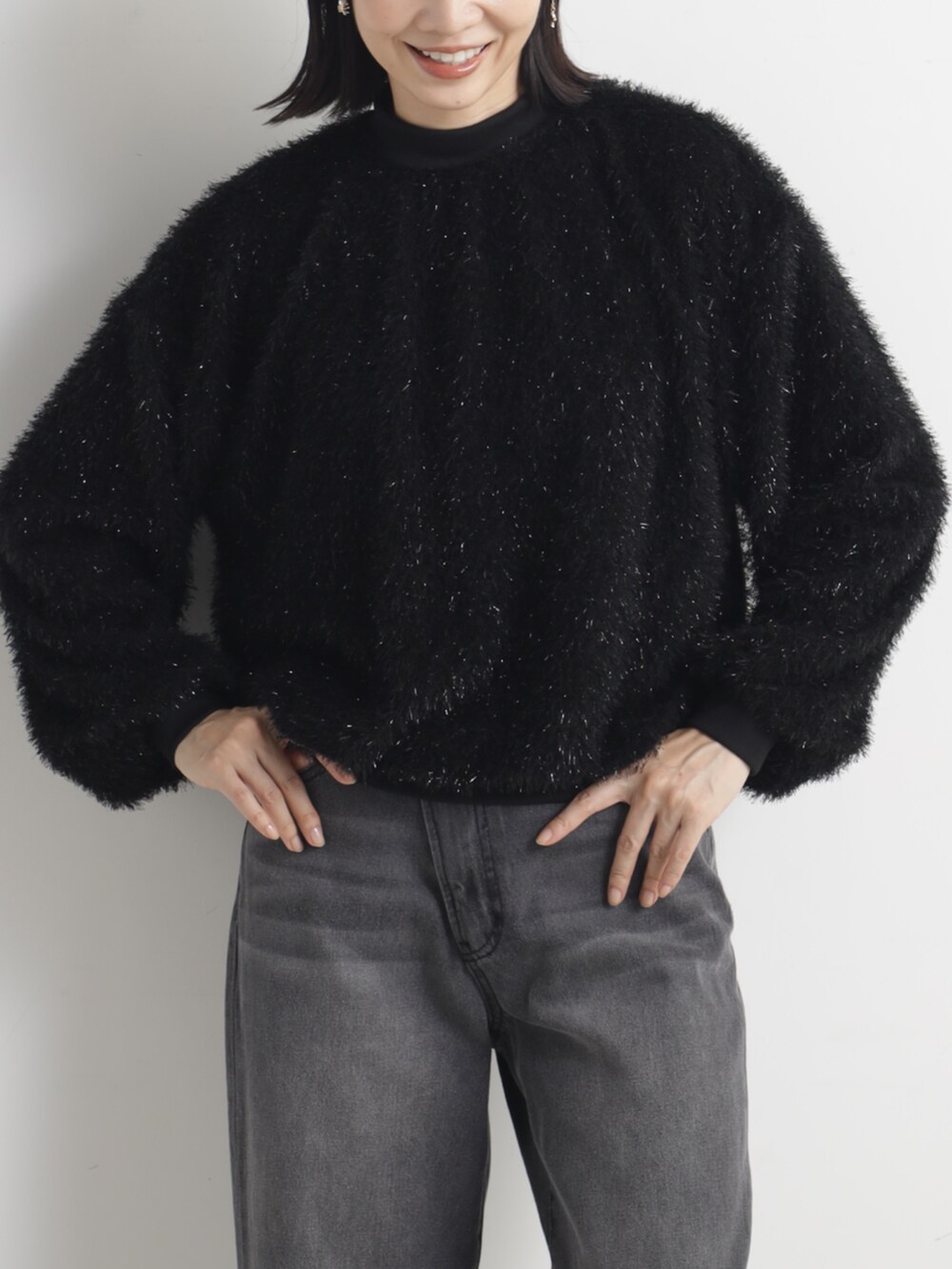 ブラック系のパンプス、グレー系のデニムパンツ、ブラック系のその他トップスを着用したレディースの冬コーディネートの2枚目の写真