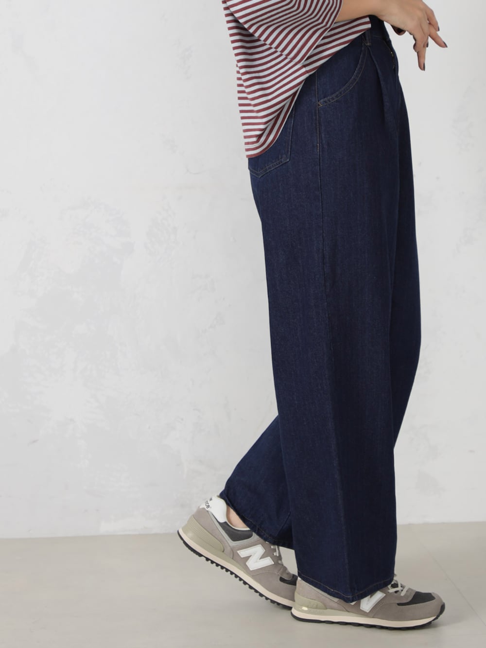 レッド系のTシャツ/カットソー、ブルー系のデニムパンツ、イエロー系のマフラーを着用したレディースの秋コーディネートの3枚目の写真