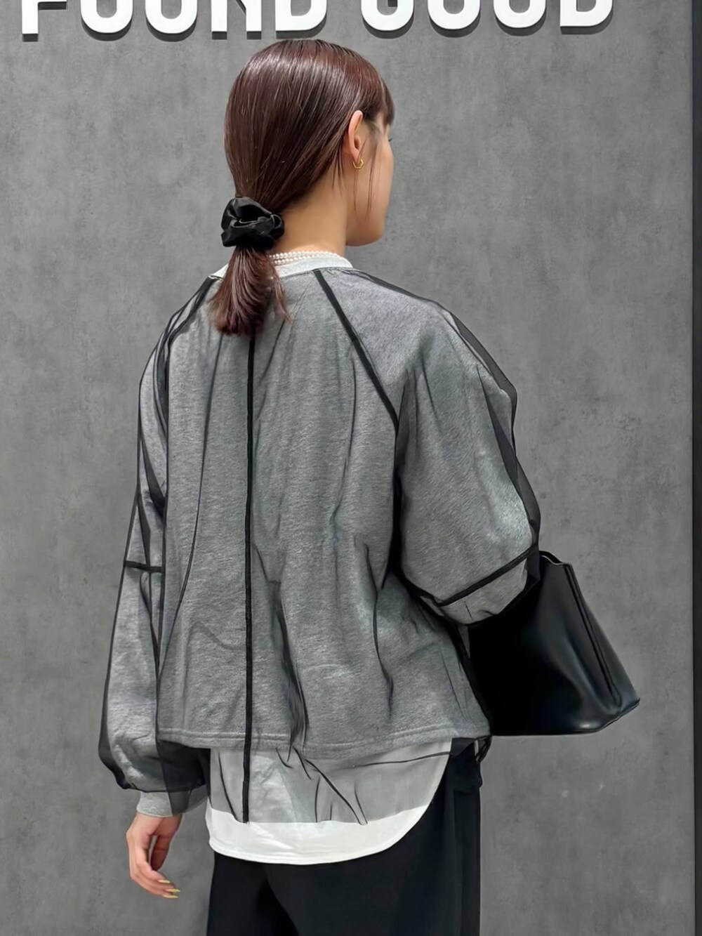 ブラック系のハンドバッグ、グレー系のTシャツ/カットソーを着用したレディースの冬コーディネートの2枚目の写真