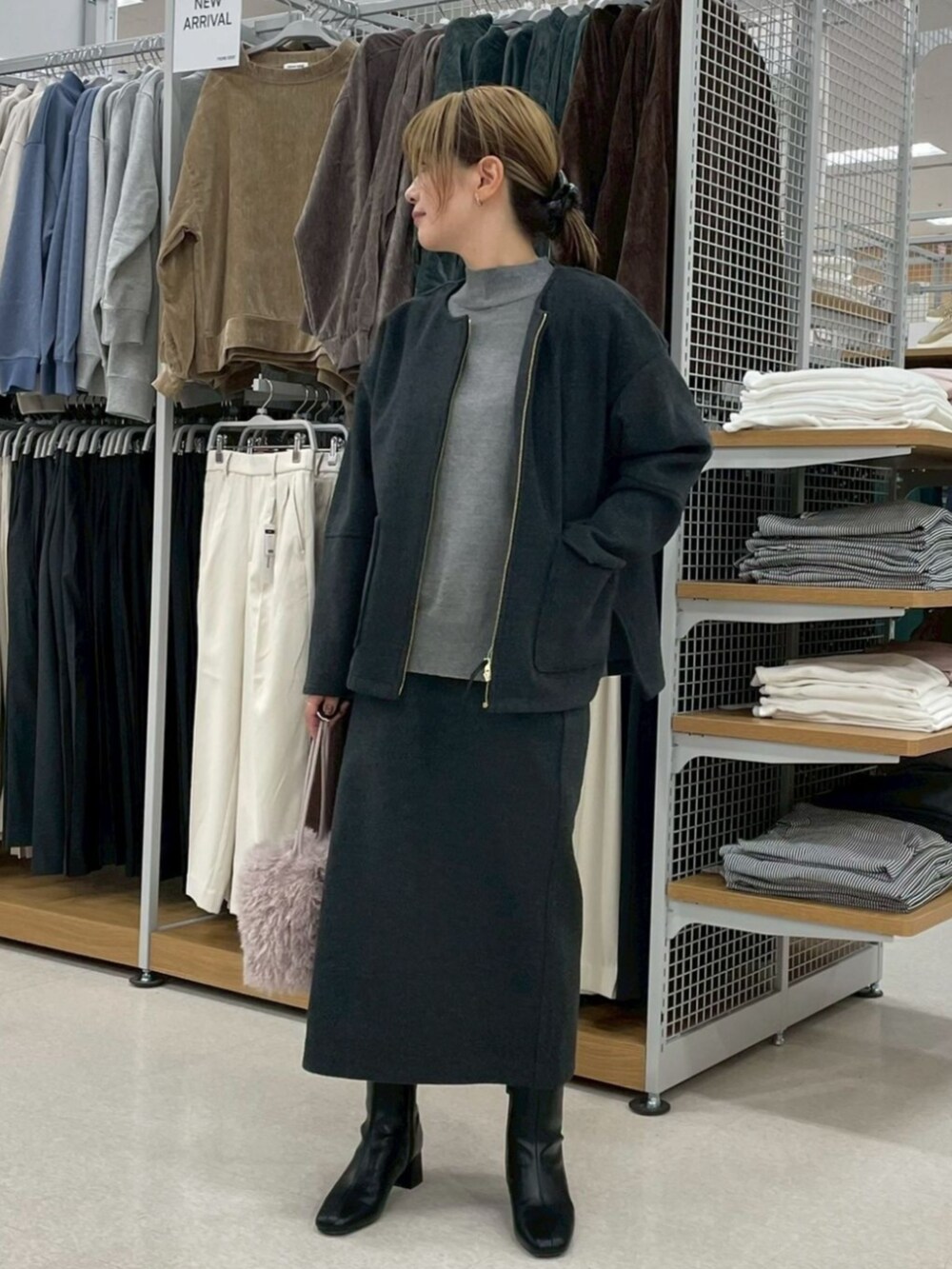 ブラック系のブルゾン、グレー系のニット/セーター、ブラック系のスカートを着用したレディースの冬コーディネートの2枚目の写真