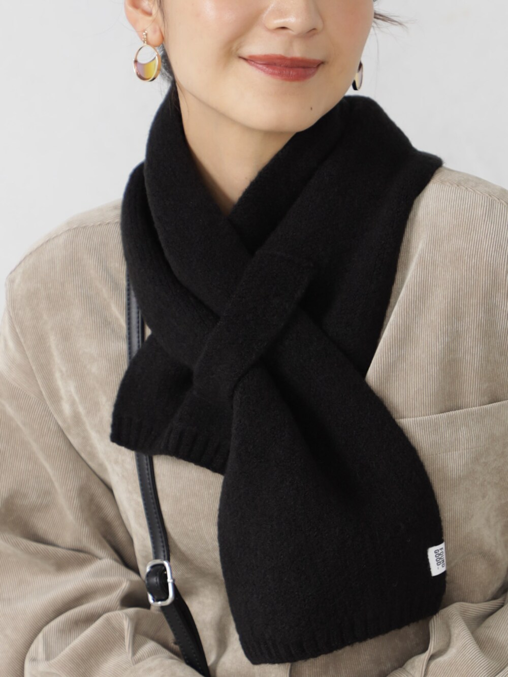 ブラック系のブーツ、ブラック系のボストンバッグ、ブラック系のスカートを着用したレディースの秋コーディネートの3枚目の写真