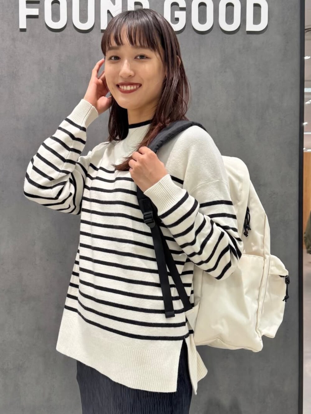 ブラック系のブーツ、グレー系のニット/セーター、ブラック系のスカートを着用したレディースの冬コーディネートの2枚目の写真