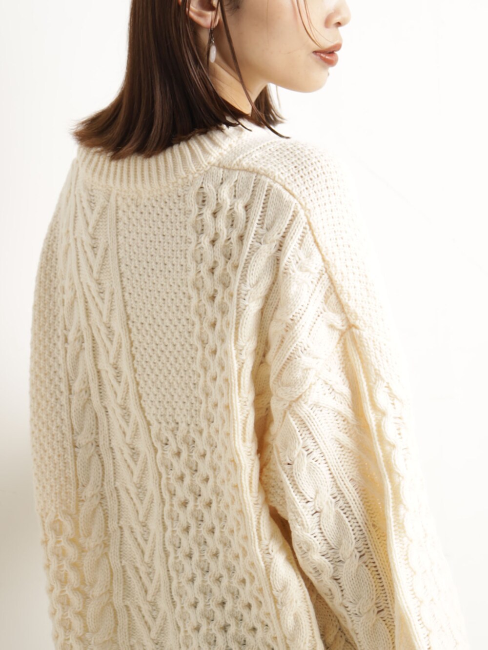 ベージュ系のニット/セーター、ベージュ系のハンドバッグ、ブルー系のスカートを着用したレディースの冬コーディネートの3枚目の写真