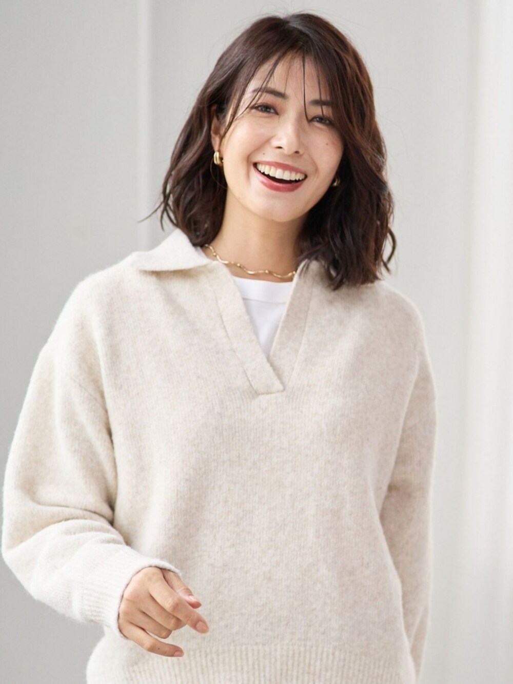 ベージュ系のニット/セーターを着用したレディースの冬コーディネートの2枚目の写真