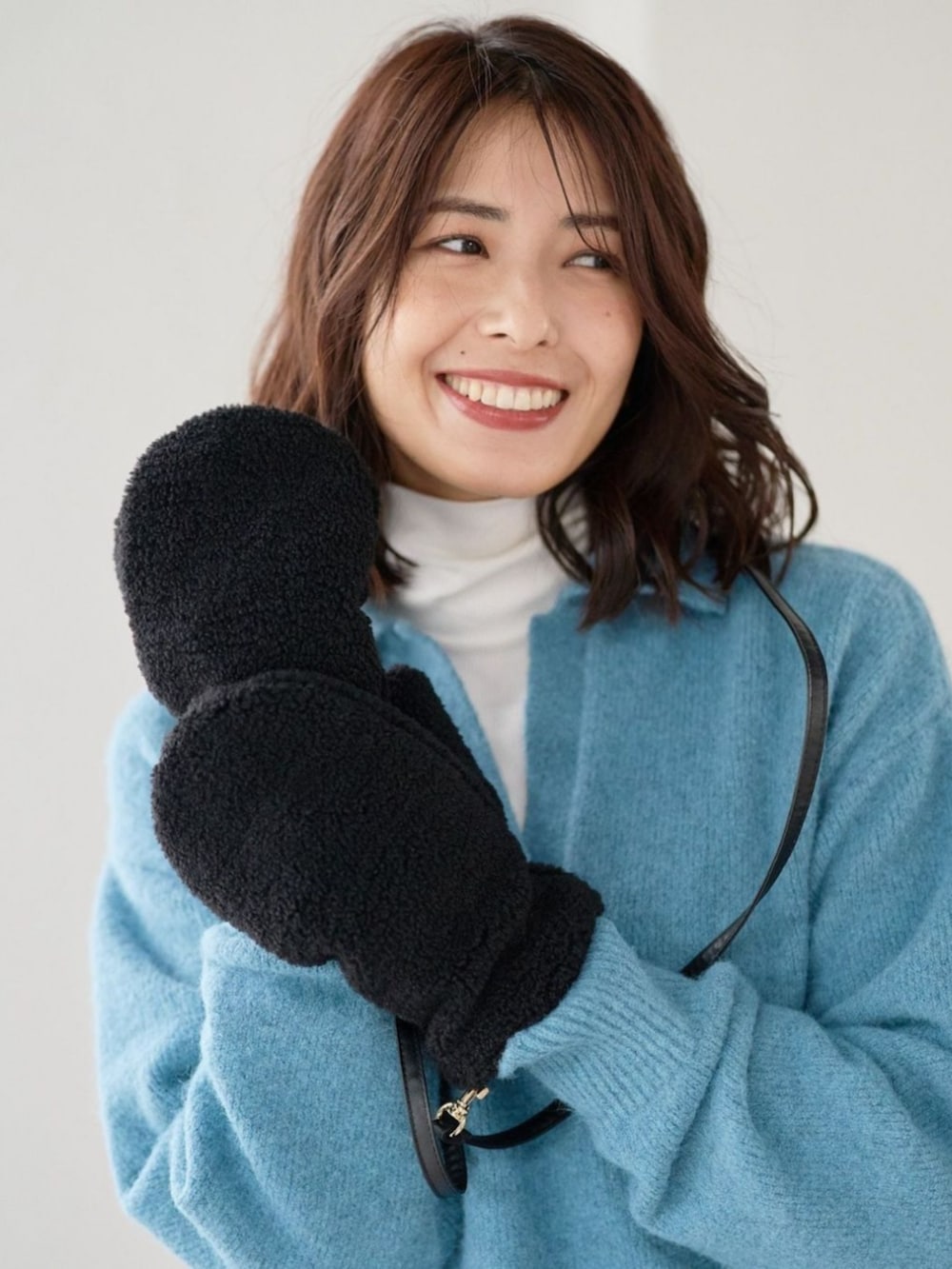 ブラック系の手袋を着用したレディースの秋コーディネートの2枚目の写真