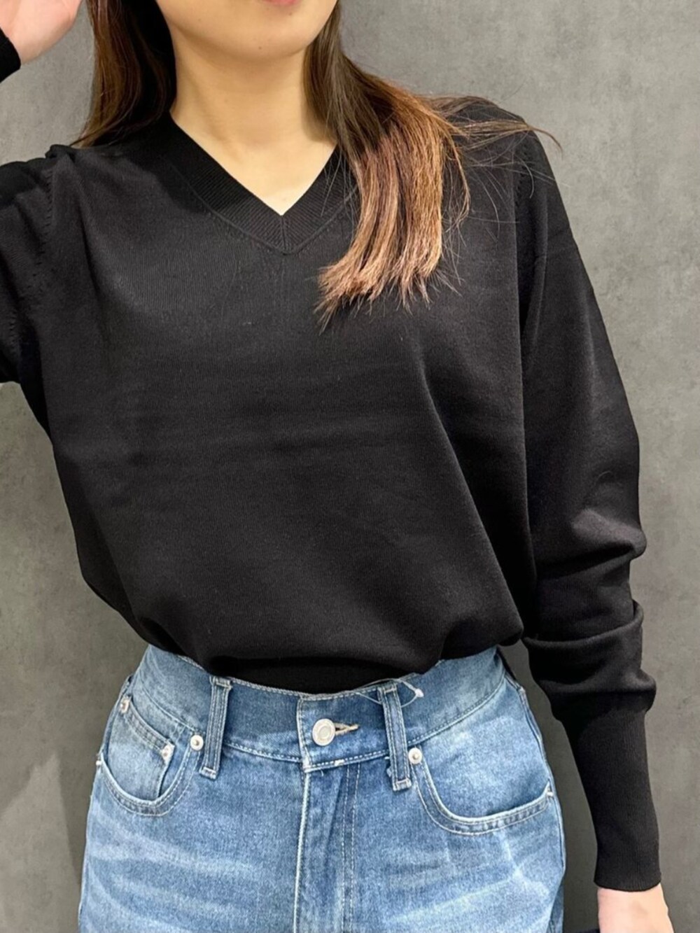 ブラック系のボストンバッグ、ブラック系のニット/セーター、ブラック系のブーツを着用したレディースの秋コーディネートの2枚目の写真