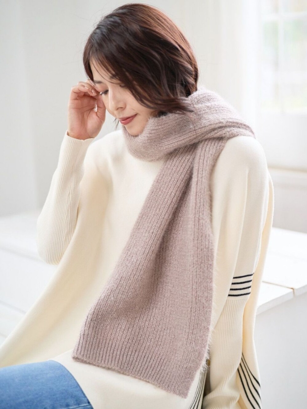 ベージュ系のマフラーを着用したレディースの秋コーディネートの2枚目の写真