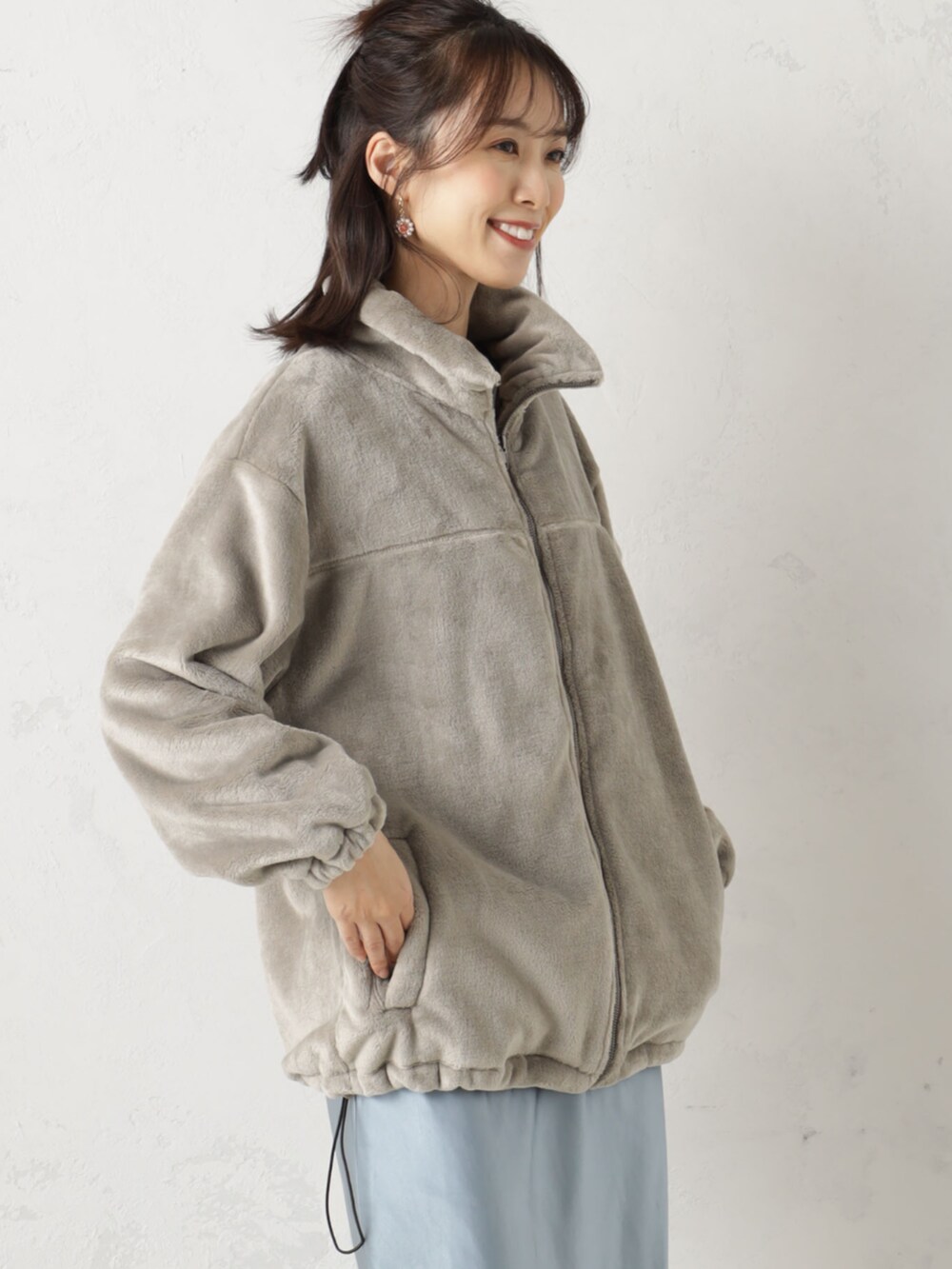 ブルー系のスカート、ベージュ系のTシャツ/カットソーを着用したレディースの冬コーディネートの2枚目の写真