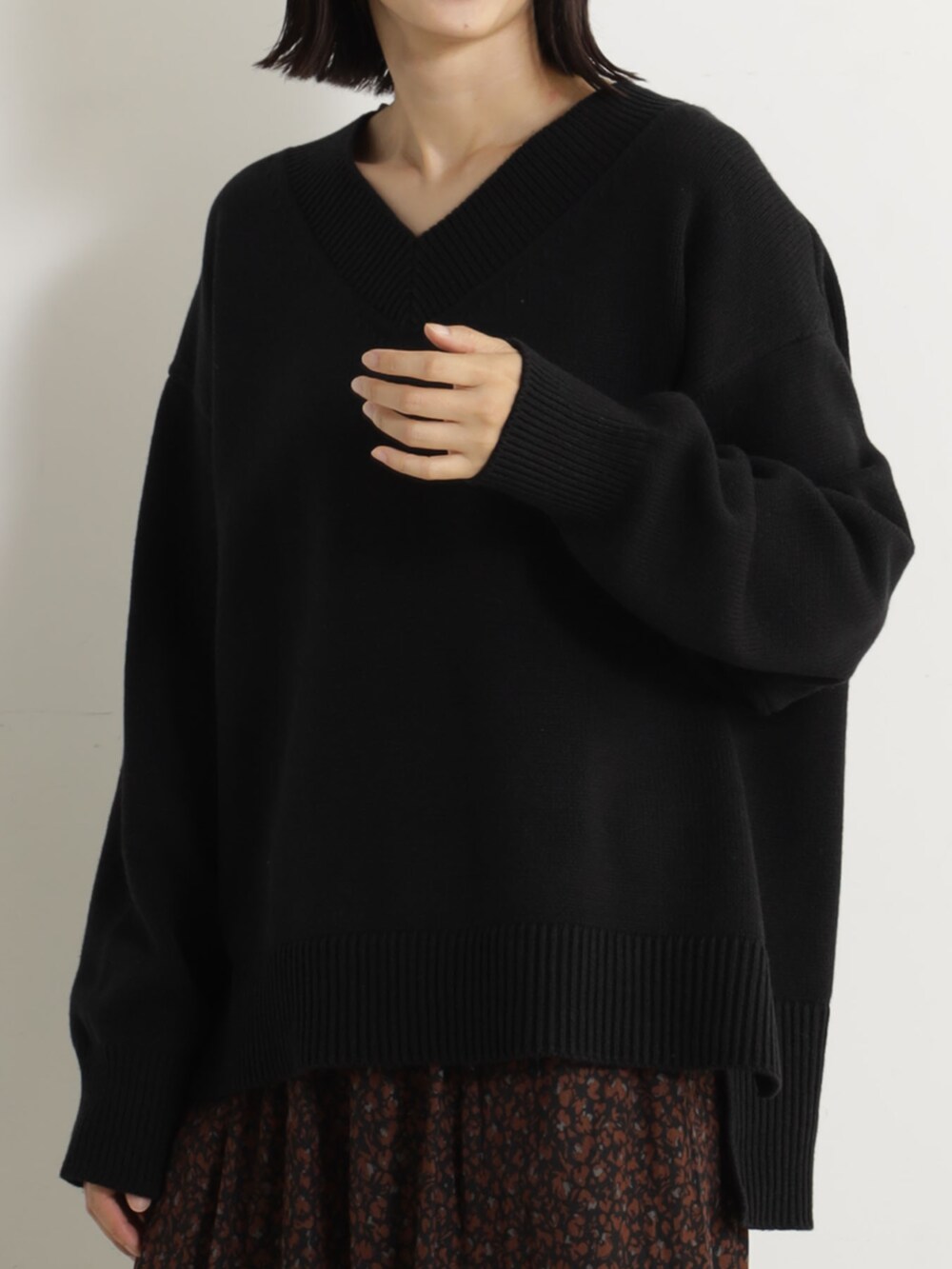 ピンク系のショルダーバッグ、ベージュ系のブーツ、ブラック系のニット/セーターを着用したレディースの冬コーディネートの3枚目の写真