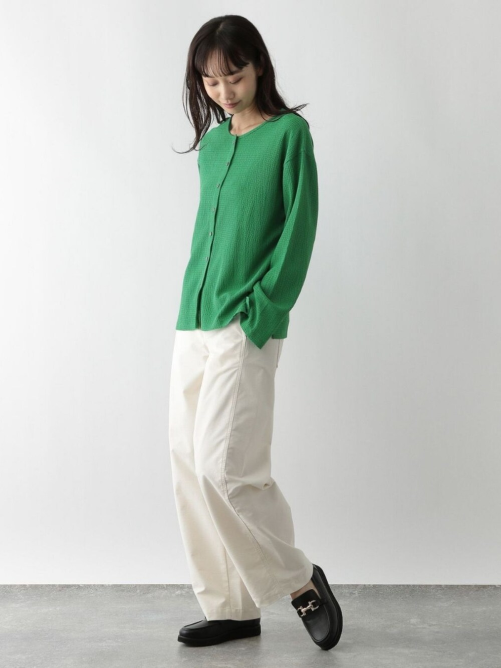 グリーン系のカーディガン/ボレロを着用したレディースの秋コーディネートの2枚目の写真
