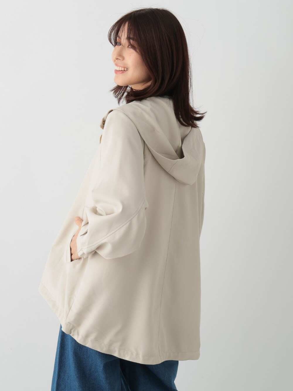 ブルー系のデニムパンツ、ベージュ系のマウンテンパーカーを着用したレディースの春コーディネートの3枚目の写真
