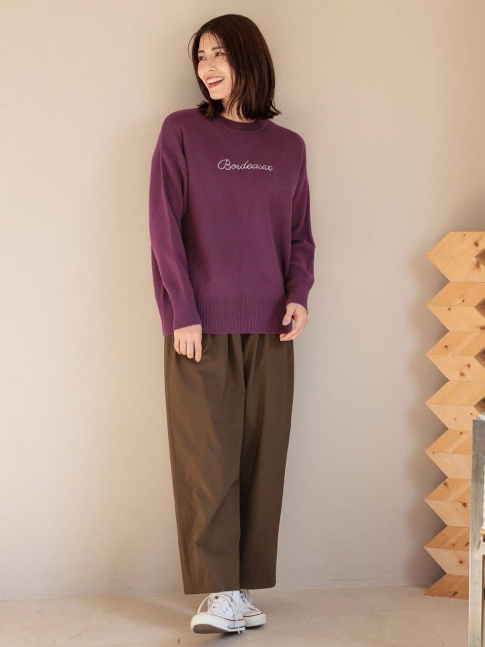 レッド系のニット/セーターを着用したレディースの冬コーディネートの2枚目の写真