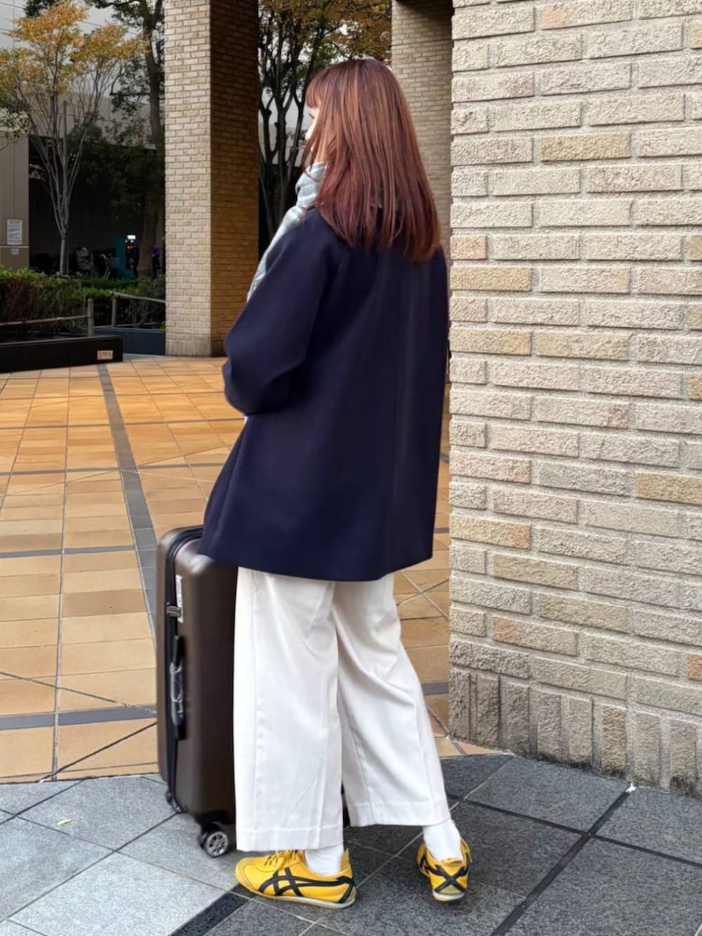 ブラウン系のスーツケース/キャリーバッグを着用したレディースの冬コーディネートの2枚目の写真