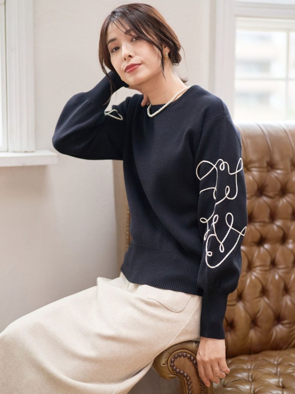 ブラック系のニット/セーターを着用したレディースの秋コーディネートの2枚目の写真