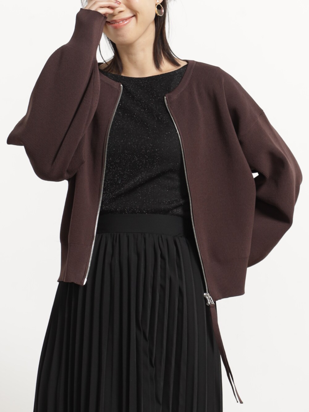 ブラウン系のブルゾン、ブラック系のスカートを着用したレディースの秋コーディネートの2枚目の写真