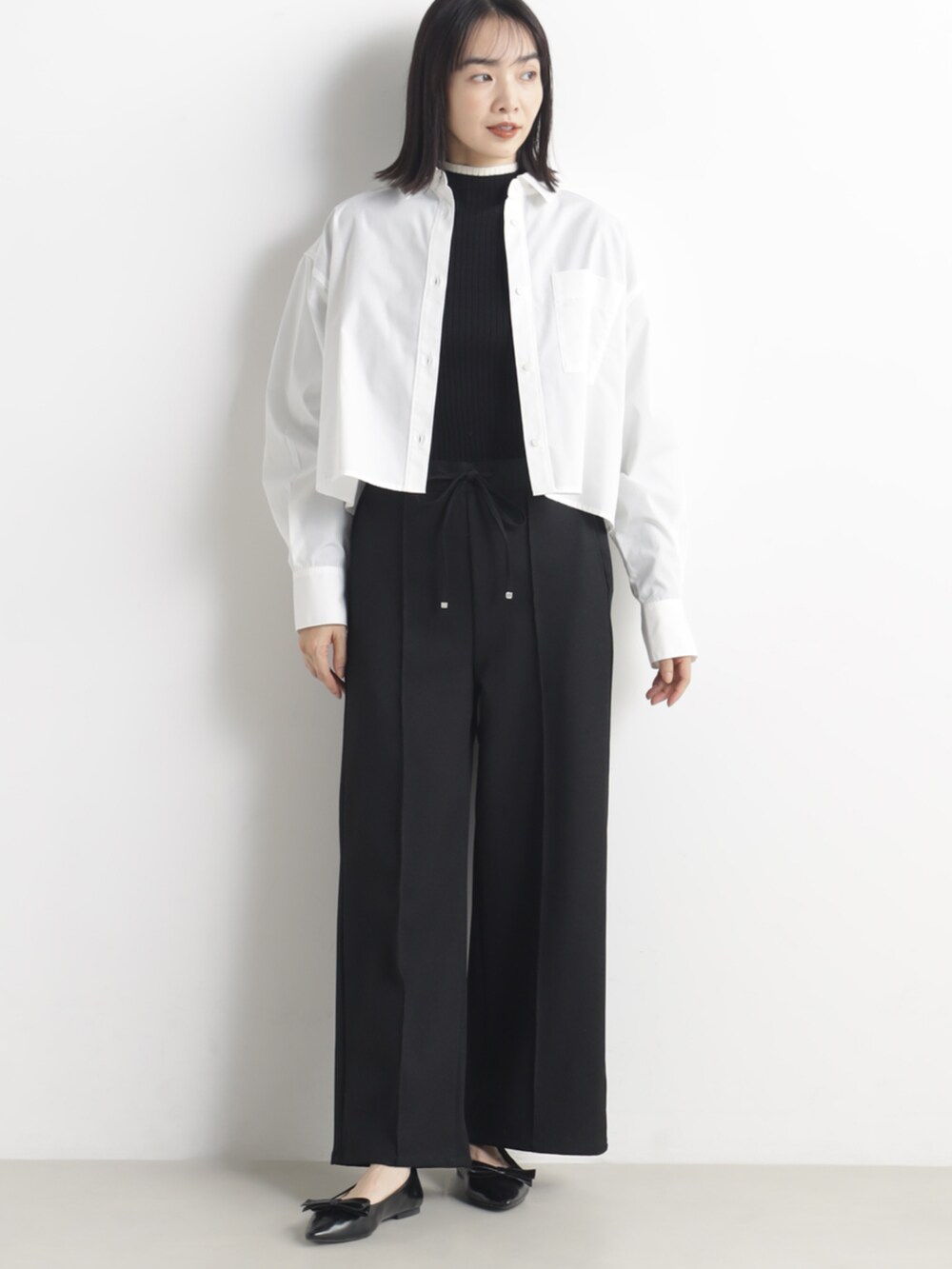 ブラック系のその他パンツ、グレー系のトートバッグを着用したレディースの春コーディネートの2枚目の写真