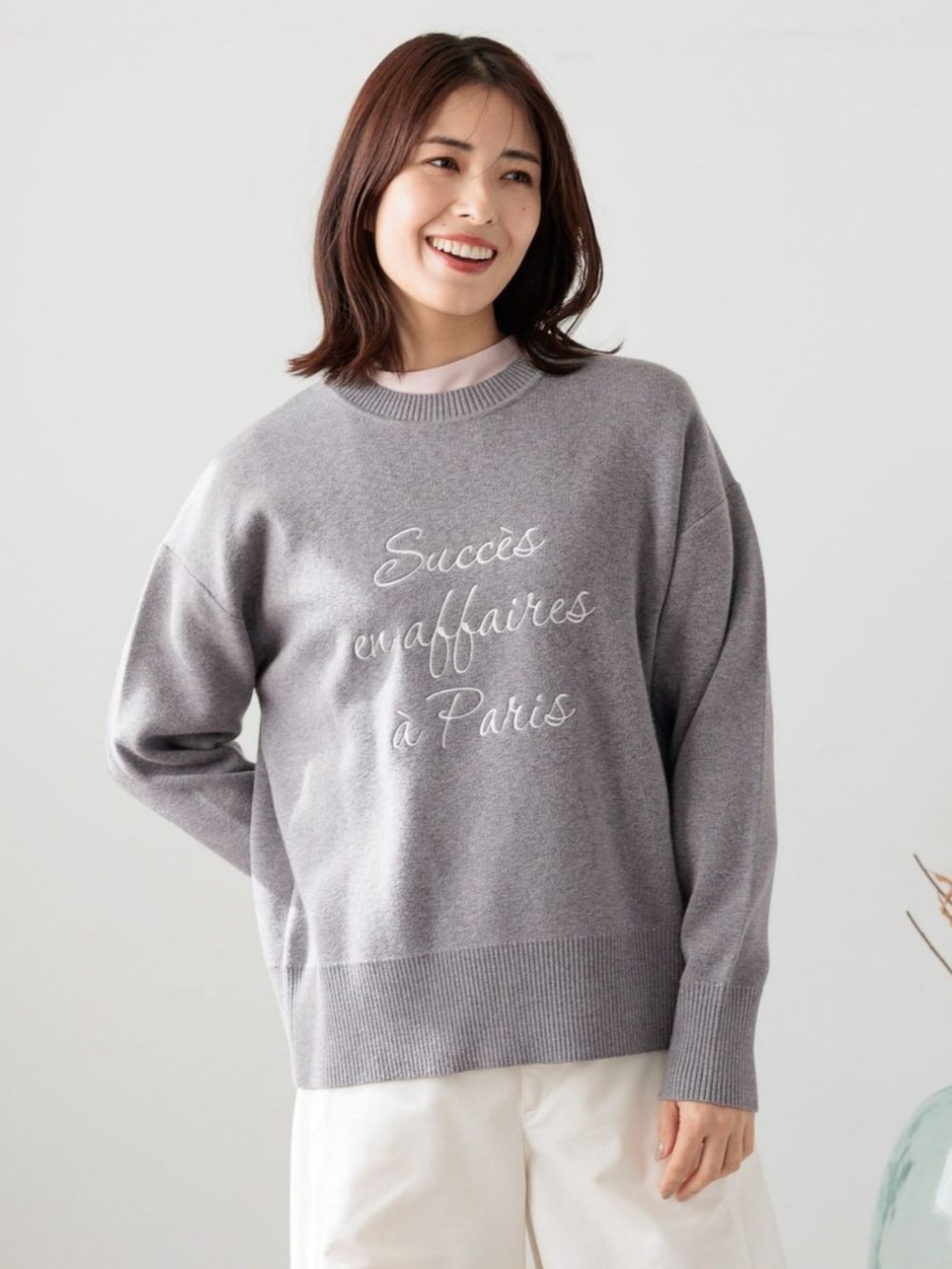 グレー系のニット/セーターを着用したレディースの冬コーディネートの2枚目の写真