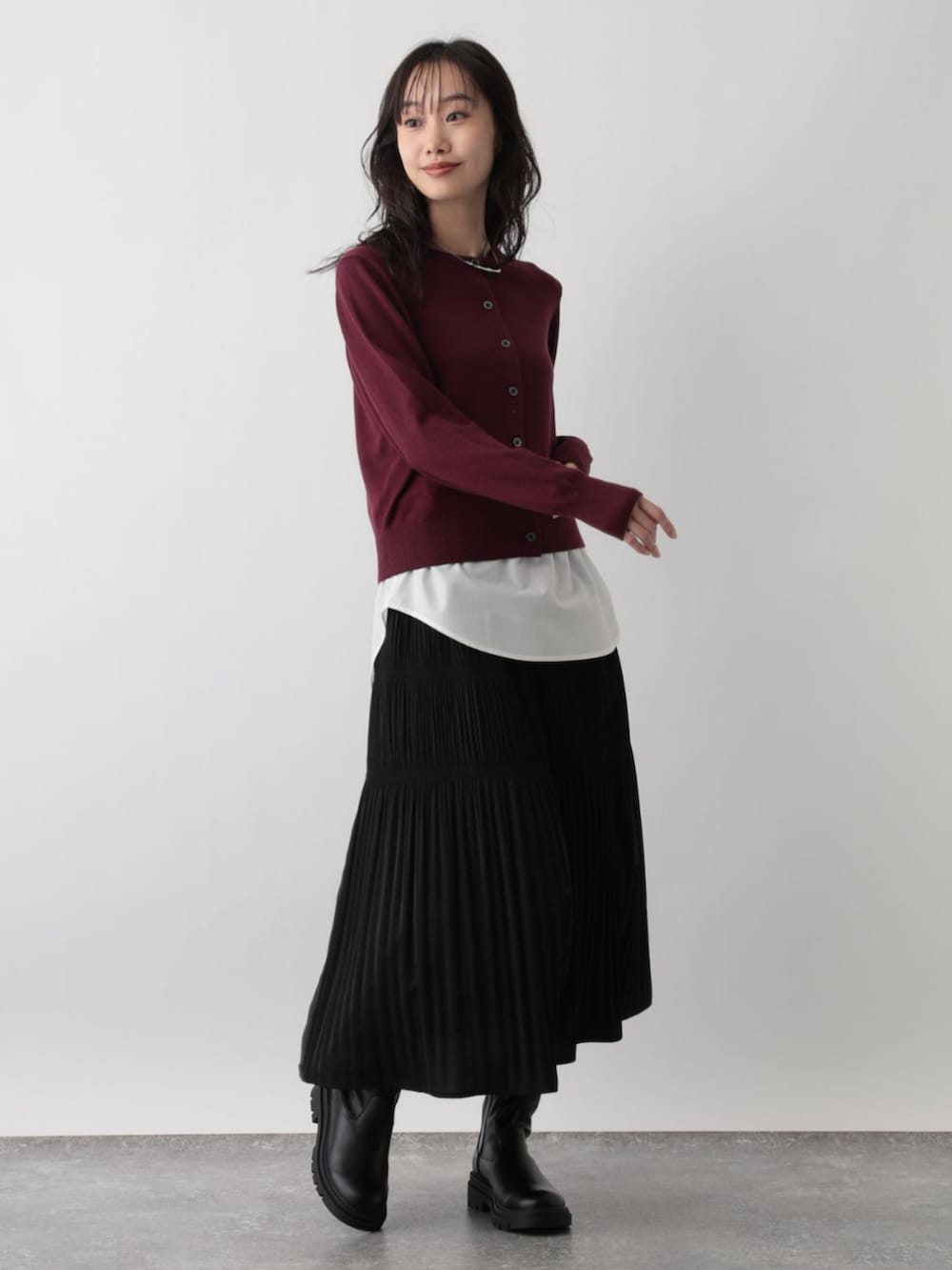 レッド系のカーディガン/ボレロ、ホワイト系のスカート、ブラック系のスカートを着用したレディースの冬コーディネートの2枚目の写真