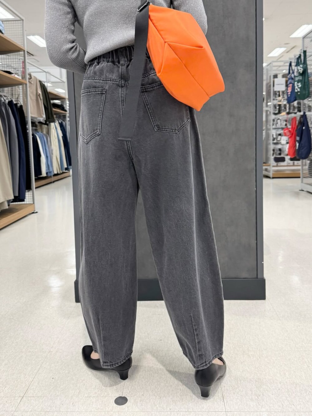 グレー系のデニムパンツ、ブラック系のパンプス、ブルー系のニット/セーターを着用したレディースの冬コーディネートの3枚目の写真