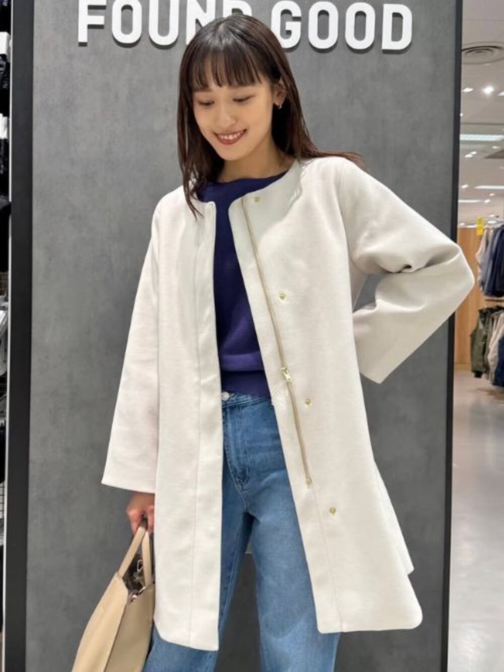 ブルー系のニット/セーター、ベージュ系のその他アウター、ブルー系のデニムパンツを着用したレディースの冬コーディネートの3枚目の写真