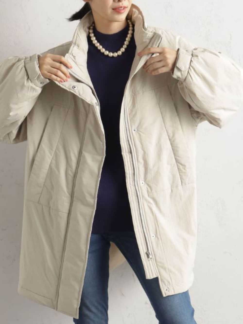 ブラック系のショルダーバッグ、ブルー系のその他パンツ、ベージュ系のその他アウターを着用したレディースの冬コーディネートの2枚目の写真