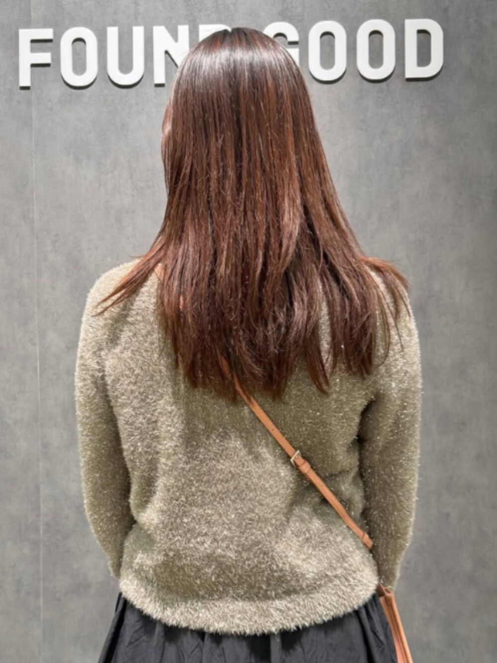 ピンク系のショルダーバッグ、ブラウン系のカーディガン/ボレロ、ブラック系のスカートを着用したレディースの冬コーディネートの2枚目の写真