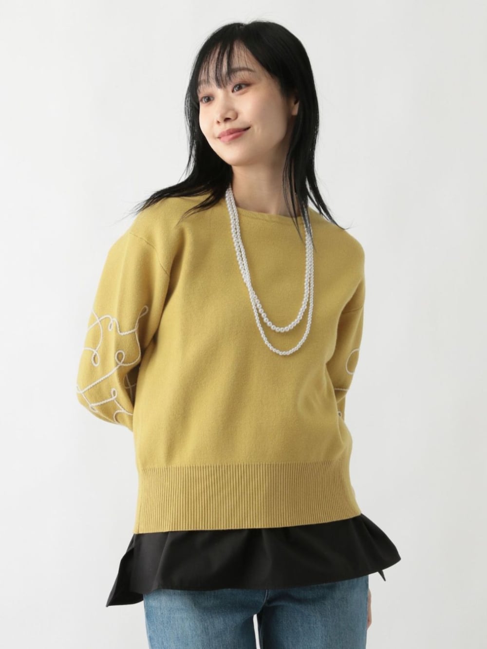 イエロー系のニット/セーターを着用したレディースの秋コーディネートの2枚目の写真