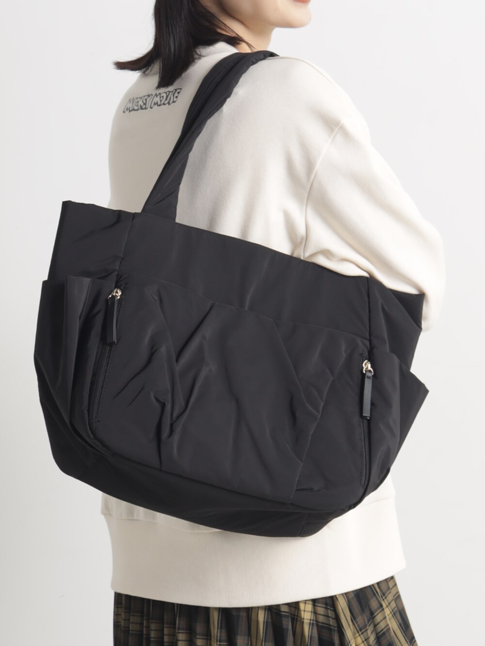 ブラウン系のスカート、ブラック系のトートバッグ、ブラウン系のキャップを着用したレディースの春コーディネートの2枚目の写真