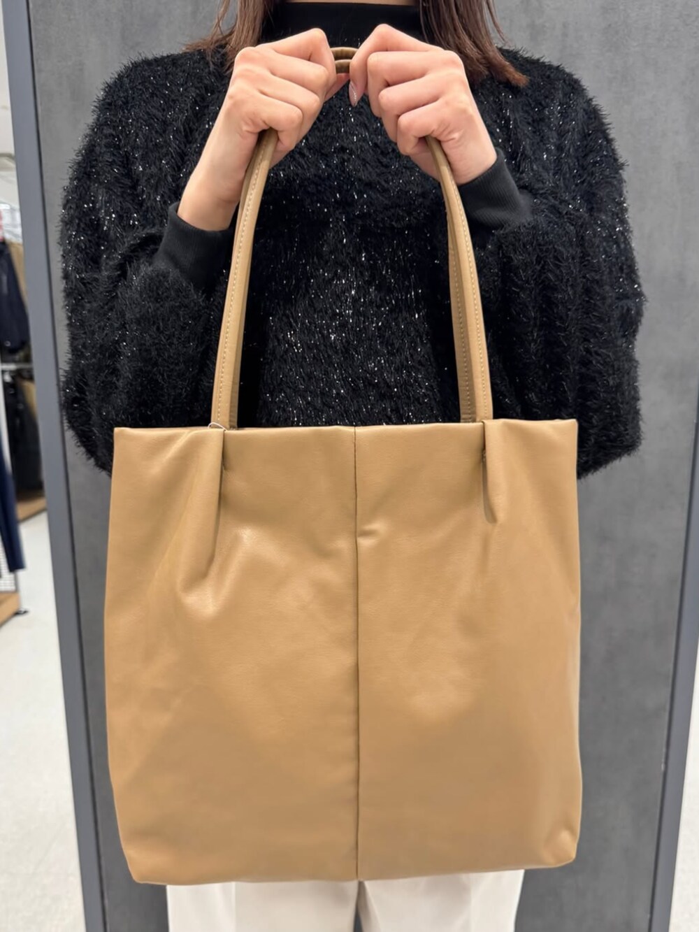 ベージュ系のトートバッグを着用したレディースの冬コーディネートの2枚目の写真