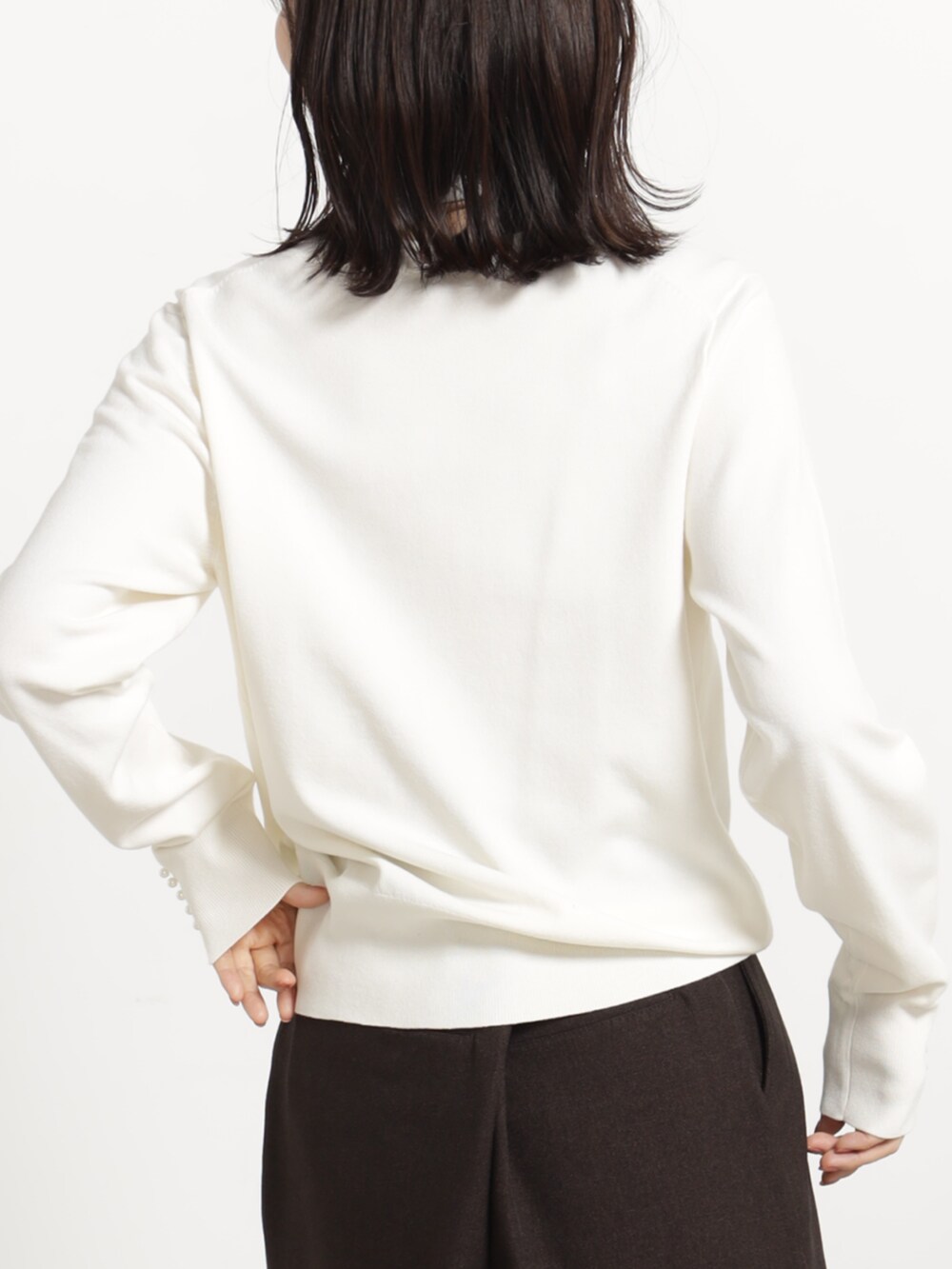 ブラウン系のその他パンツ、ホワイト系のニット/セーター、ブラック系のボストンバッグを着用したレディースの秋コーディネートの4枚目の写真