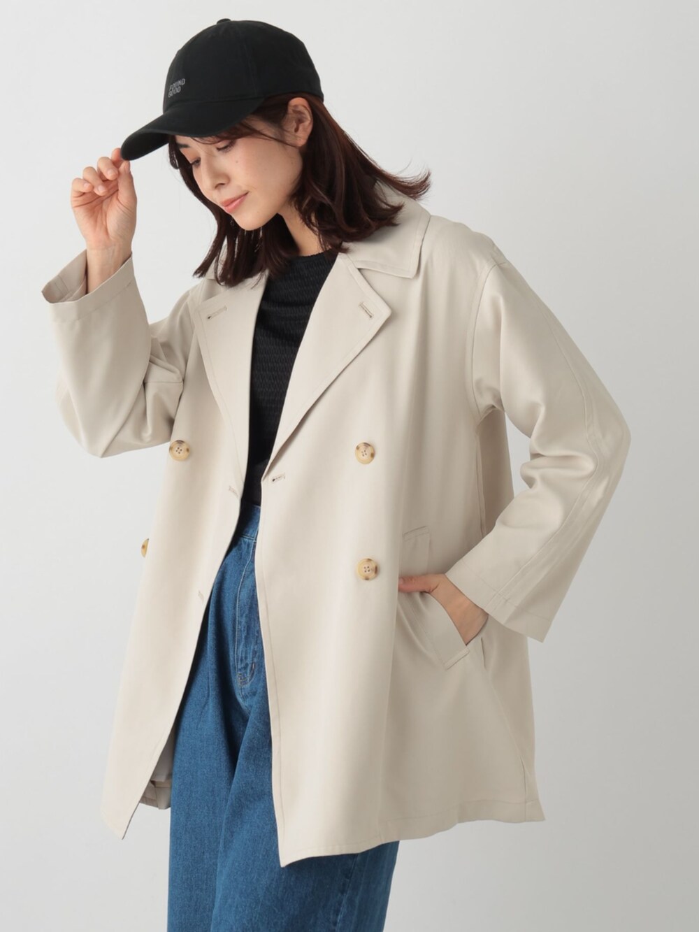 ブルー系のデニムパンツ、ベージュ系のトレンチコートを着用したレディースの春コーディネートの2枚目の写真