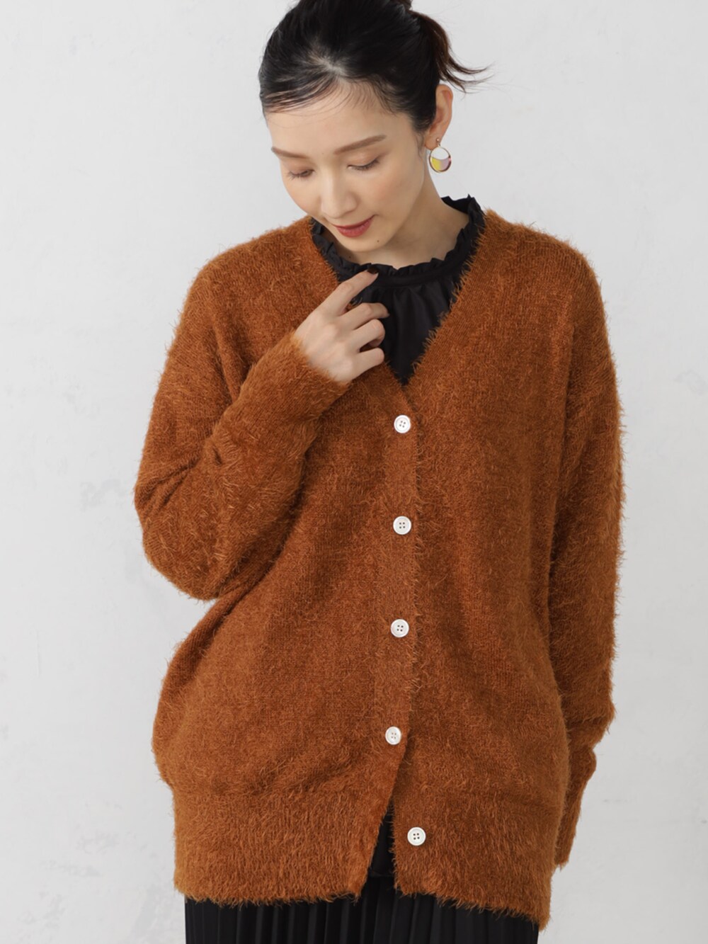 ブラウン系のカーディガン/ボレロを着用したレディースの秋コーディネートの2枚目の写真