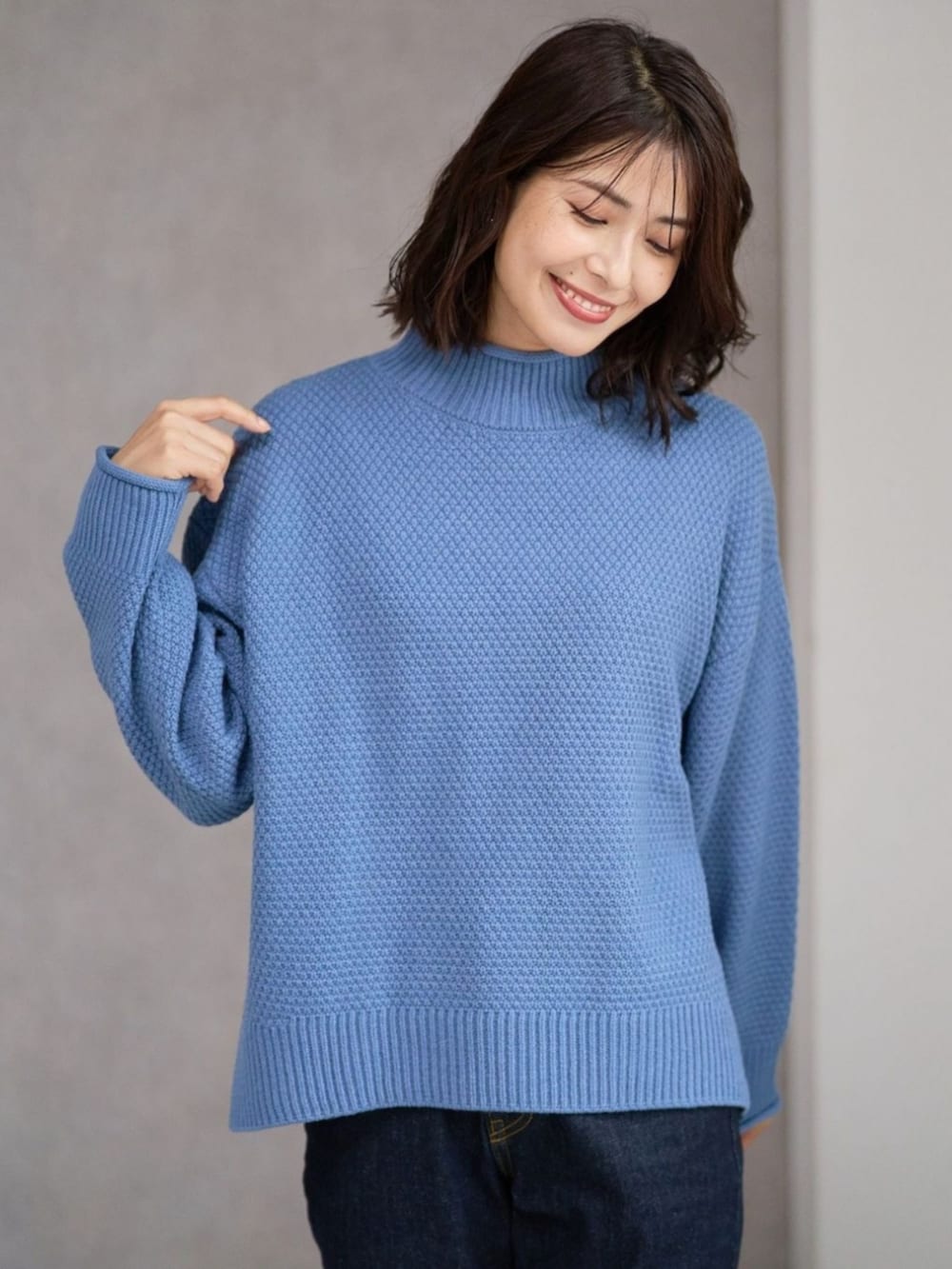 ブラウン系のブルゾン、ブルー系のニット/セーターを着用したレディースの冬コーディネートの2枚目の写真