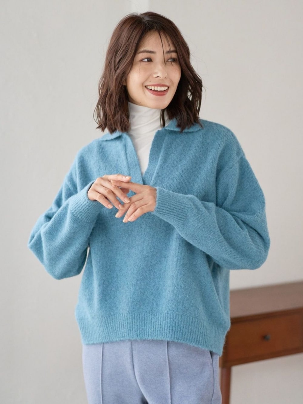 ブルー系のニット/セーターを着用したレディースの冬コーディネートの3枚目の写真
