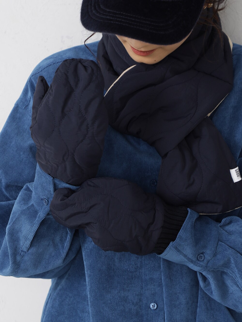 ブルー系のシャツ/ブラウス、ブラック系のキャップ、ブルー系のマフラーを着用したレディースの秋コーディネートの2枚目の写真