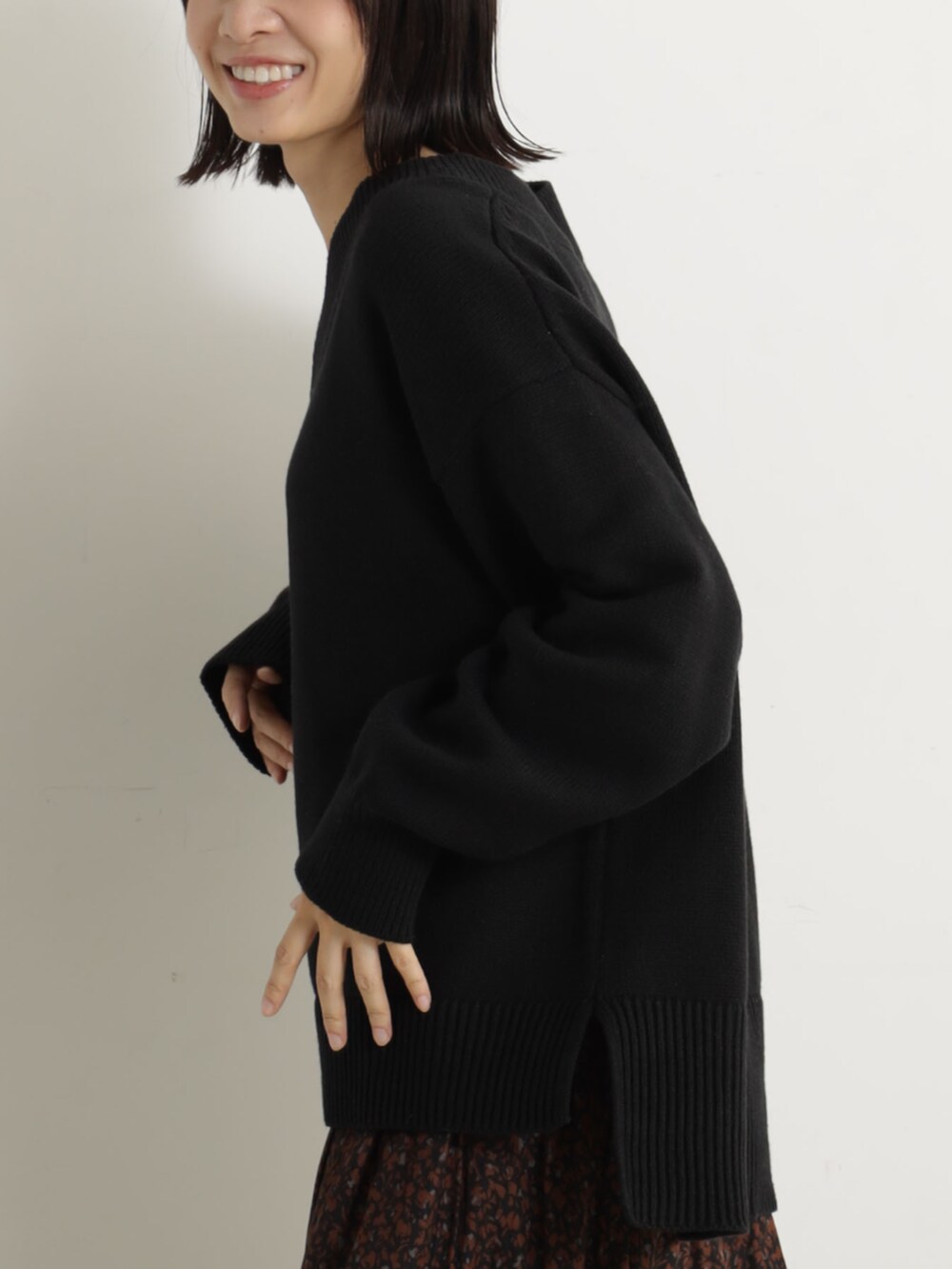 ピンク系のショルダーバッグ、ベージュ系のブーツ、ブラック系のニット/セーターを着用したレディースの冬コーディネートの4枚目の写真