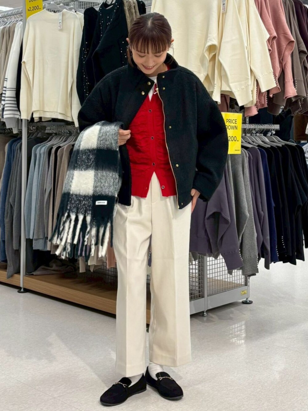 レッド系のカーディガン/ボレロ、ブラック系のブルゾンを着用したレディースの冬コーディネートの2枚目の写真