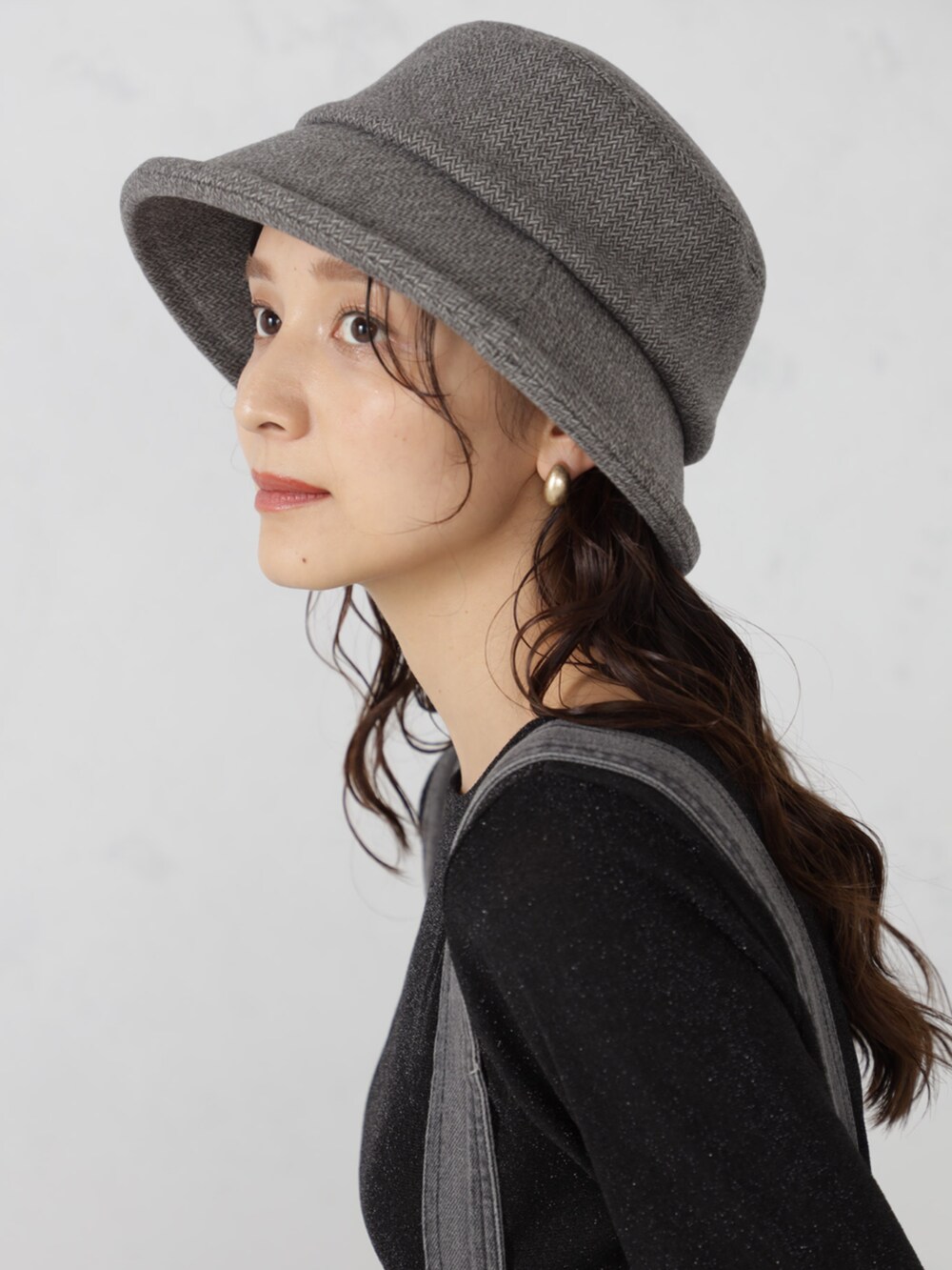 グレー系のサロペット/オーバーオール、ブラウン系のハットを着用したレディースの秋コーディネートの4枚目の写真