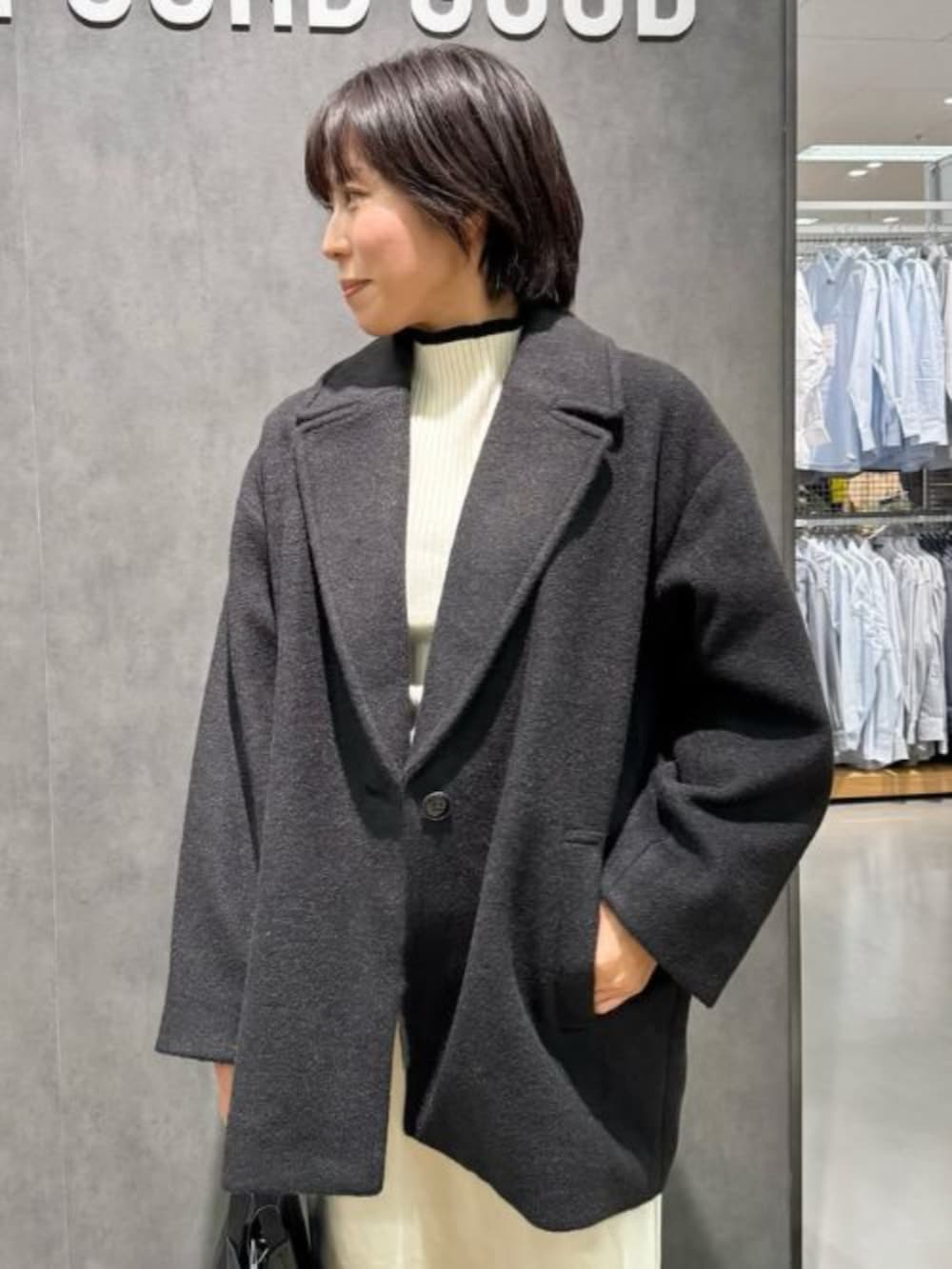 ブラック系のその他アウター、ベージュ系のスカート、ベージュ系のニット/セーターを着用したレディースの冬コーディネートの2枚目の写真