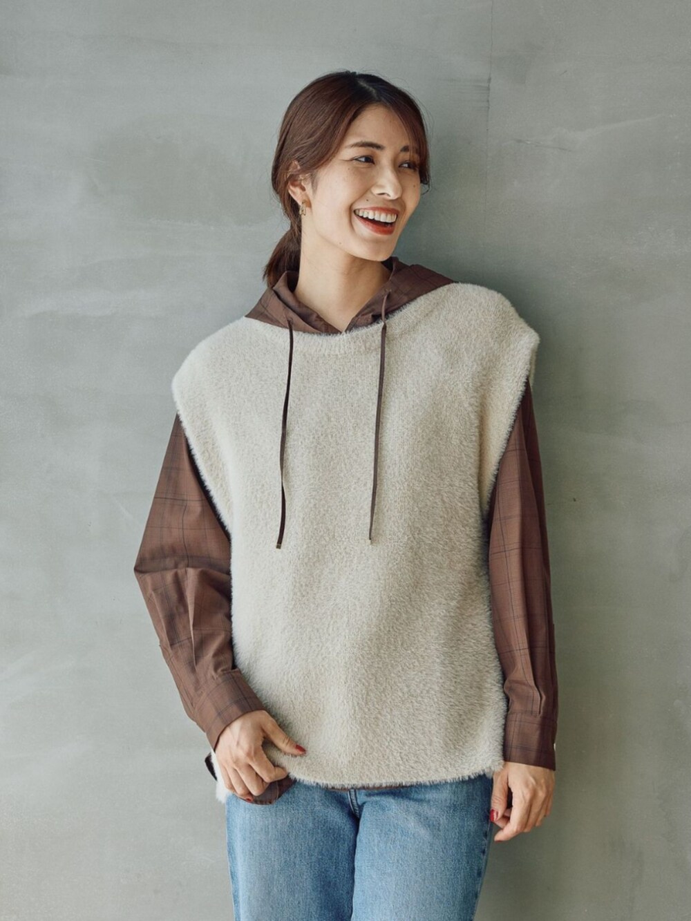 ベージュ系のベストを着用したレディースの秋コーディネートの3枚目の写真