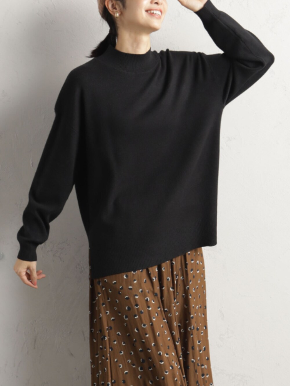 ブラック系のニット/セーター、ブラウン系のその他パンツを着用したレディースの冬コーディネートの2枚目の写真