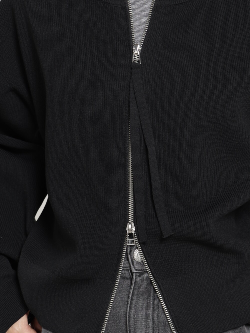 グレー系のデニムパンツ、ブラック系のブルゾンを着用したレディースの秋コーディネートの3枚目の写真