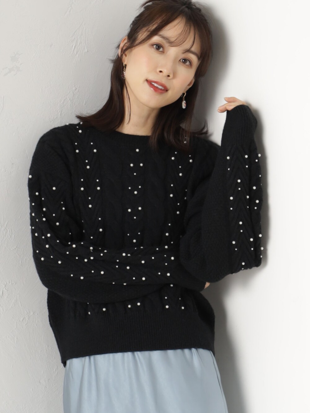 ブラック系のニット/セーター、ブルー系のスカートを着用したレディースの冬コーディネートの2枚目の写真