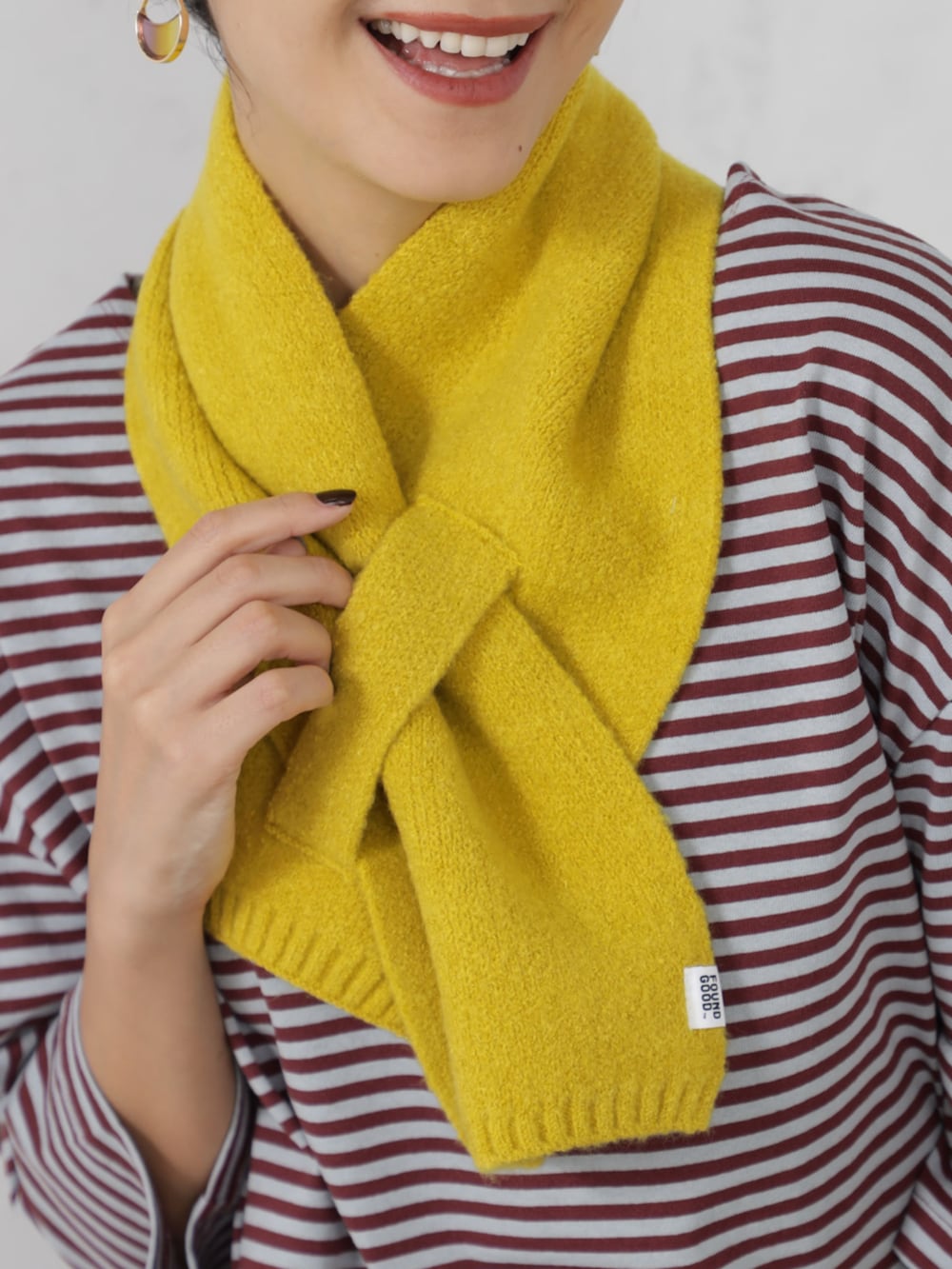 レッド系のTシャツ/カットソー、ブルー系のデニムパンツ、イエロー系のマフラーを着用したレディースの秋コーディネートの2枚目の写真