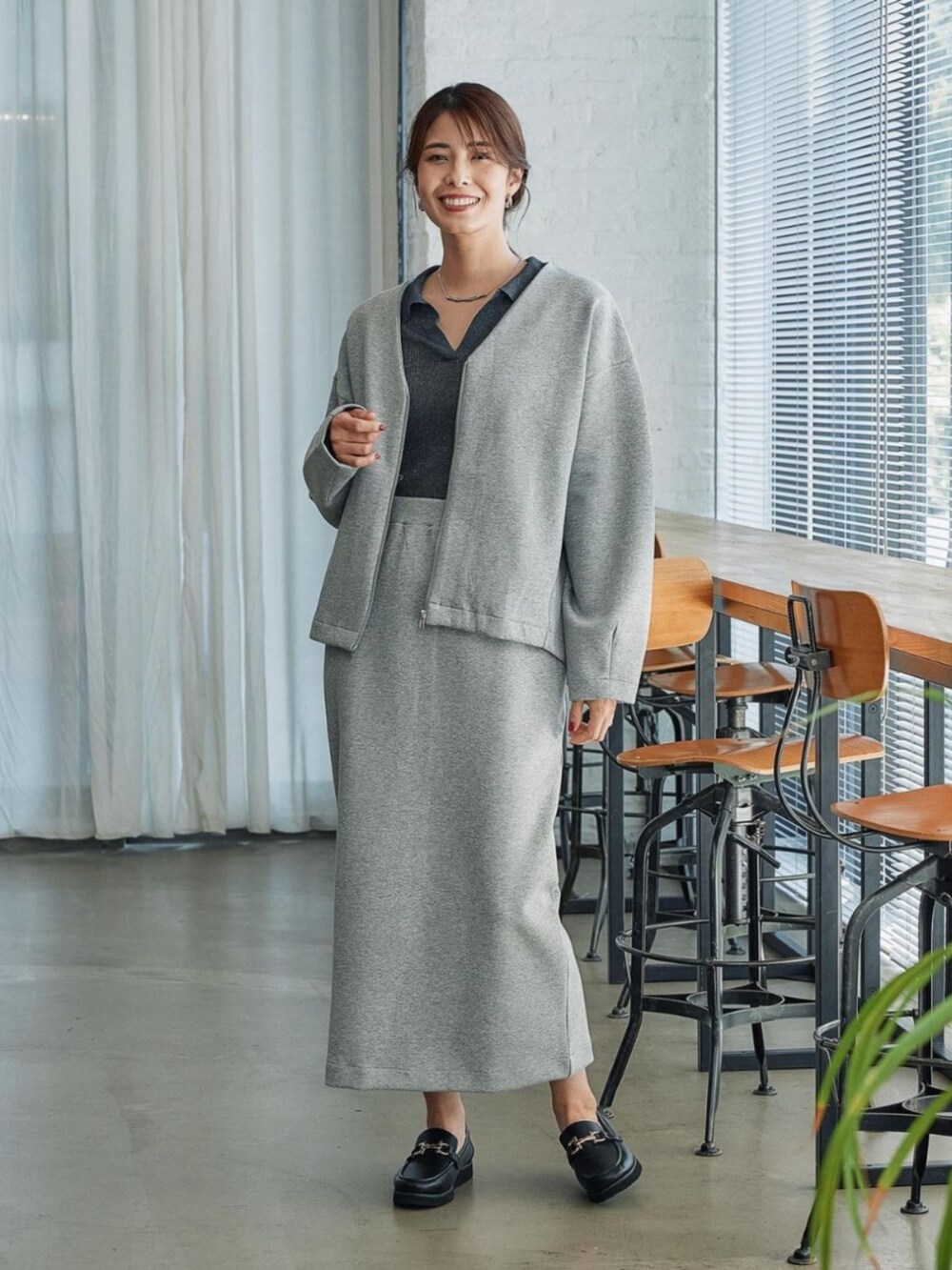 グレー系のブルゾンを着用したレディースの秋コーディネートの2枚目の写真